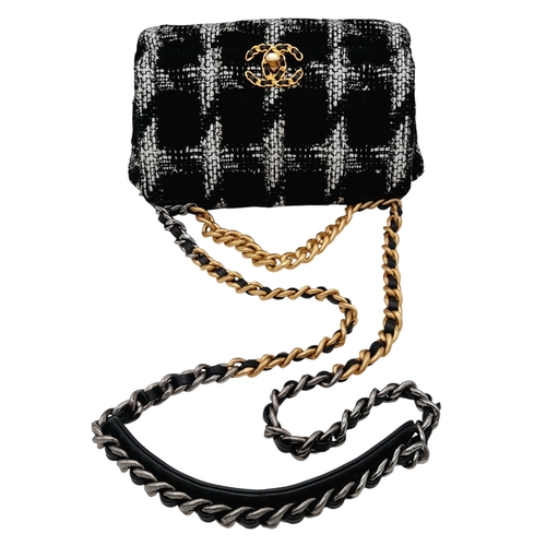 34 - A Chanel Black and White Tweed Flap Bag. Quilted tweed exterior with gold toned hardware, leather-in... 