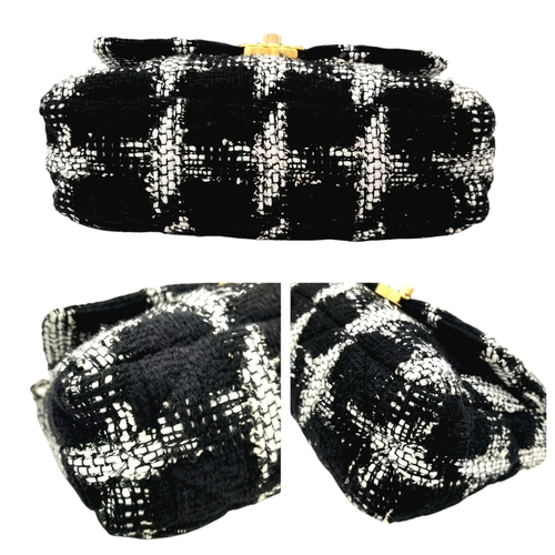 34 - A Chanel Black and White Tweed Flap Bag. Quilted tweed exterior with gold toned hardware, leather-in... 