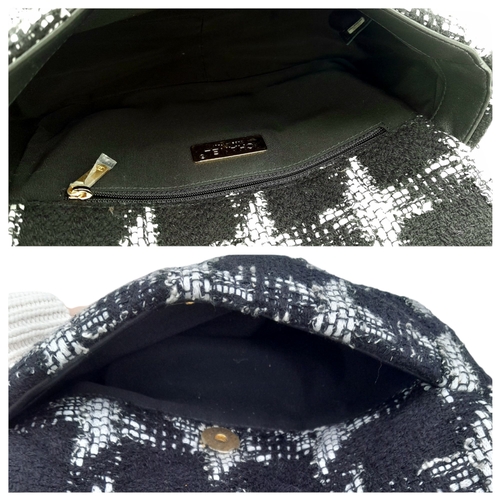 34 - A Chanel Black and White Tweed Flap Bag. Quilted tweed exterior with gold toned hardware, leather-in... 