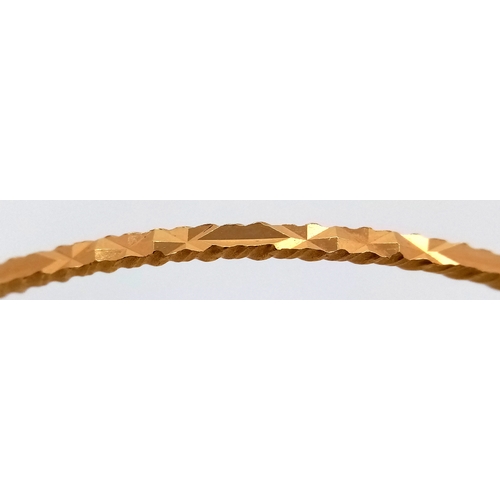 52 - An 18K Yellow Gold (test as) Bangle with Geometric Pattern. 3mm width. 65mm inner diameter. 10.1g.