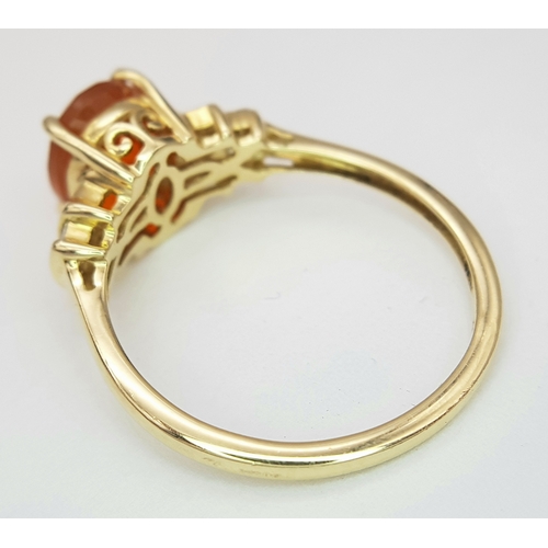 43 - A 14K Yellow Gold, Fire Opal and Diamond Ring. Oval cut 1.5ct fire opal with tapered baguette diamon... 