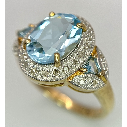 19 - A 14K Yellow Gold, Blue Topaz and Diamond Ring. 3ct oval cut, ice blue central topaz with 0.14ctw of... 