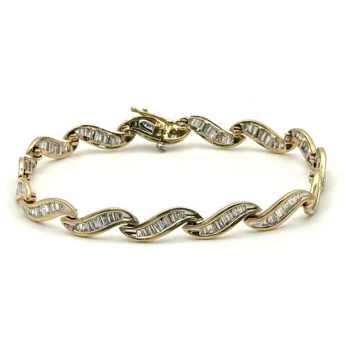 199 - A 14k Yellow Gold and Diamond Bracelet. Fifteen waves of tapered baguette cut diamonds - c.2.5ctw. 1... 