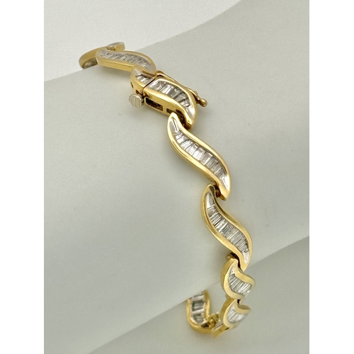 199 - A 14k Yellow Gold and Diamond Bracelet. Fifteen waves of tapered baguette cut diamonds - c.2.5ctw. 1... 