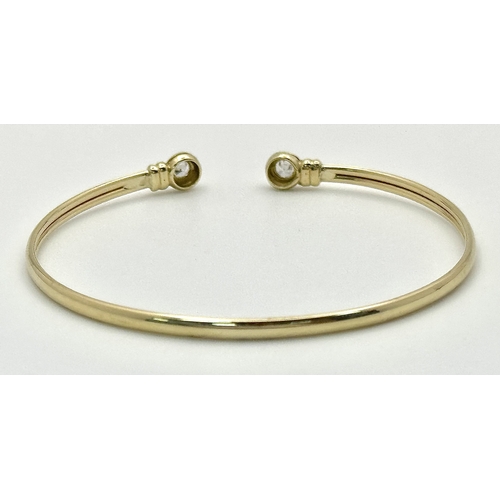 234 - A 9K Yellow Gold Cuff Bangle with White Stone Decoration. 3.1g total weight.
