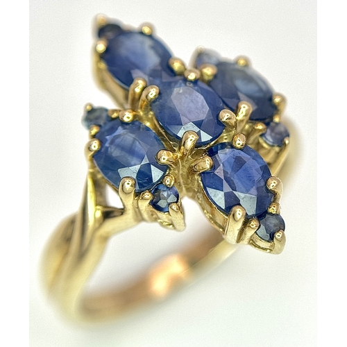 186 - A 9k Yellow Gold, Blue Sapphire Ring. Four 1.840ctw Oval cut Nigerian Sapphires with further accents... 