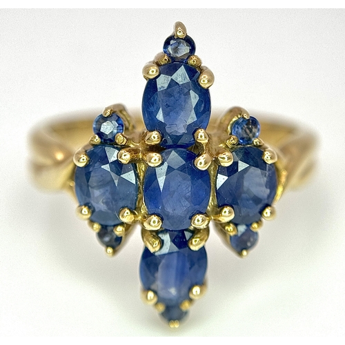 186 - A 9k Yellow Gold, Blue Sapphire Ring. Four 1.840ctw Oval cut Nigerian Sapphires with further accents... 