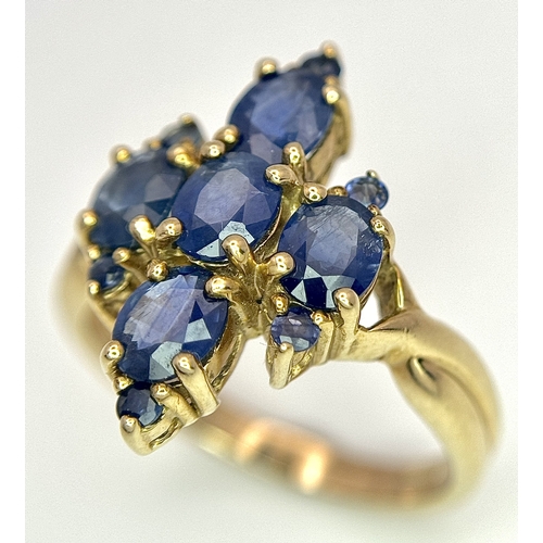186 - A 9k Yellow Gold, Blue Sapphire Ring. Four 1.840ctw Oval cut Nigerian Sapphires with further accents... 