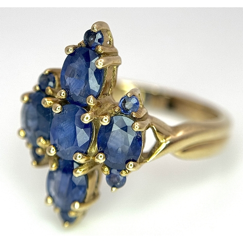 186 - A 9k Yellow Gold, Blue Sapphire Ring. Four 1.840ctw Oval cut Nigerian Sapphires with further accents... 