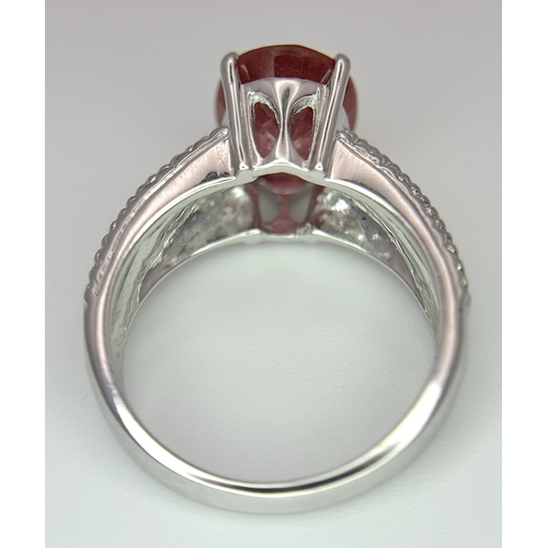 193 - An 18K White Gold, Royal Ruby and Diamond Ring. A 5.038 Madagascan oval cut Royal ruby with 0.084ctw... 