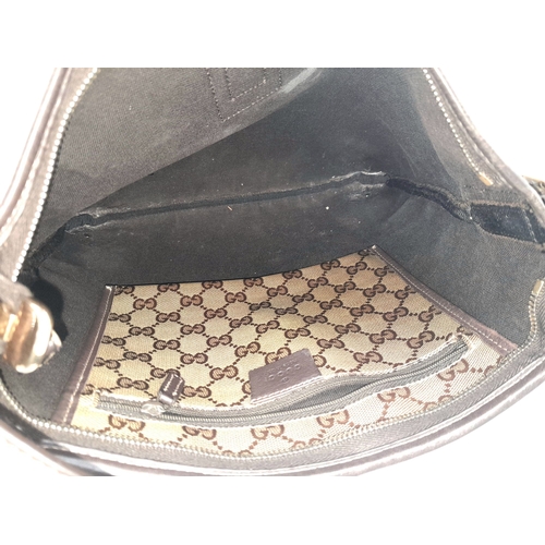 208 - A Gucci Brown GG Monogram Canvas Crossbody Bag. Brown GG monogram canvas exterior with gold-toned ha... 