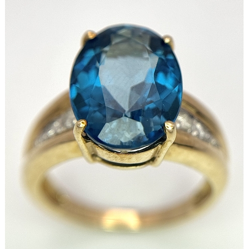 262 - A 9K Yellow Gold, London Blue Topaz and Diamond Ring. A 5.979ct, oval cut topaz with 0.056ct of Diam... 