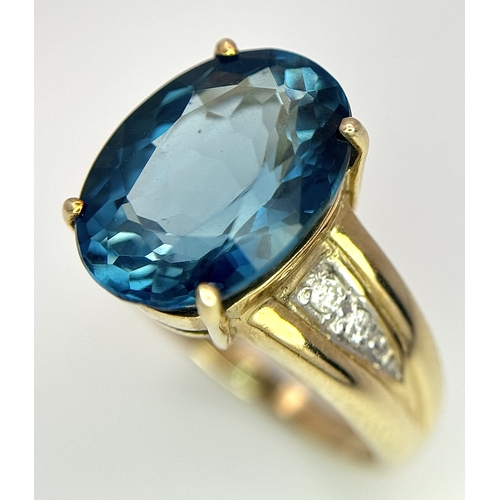 262 - A 9K Yellow Gold, London Blue Topaz and Diamond Ring. A 5.979ct, oval cut topaz with 0.056ct of Diam... 