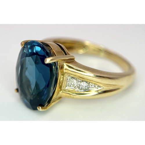 262 - A 9K Yellow Gold, London Blue Topaz and Diamond Ring. A 5.979ct, oval cut topaz with 0.056ct of Diam... 