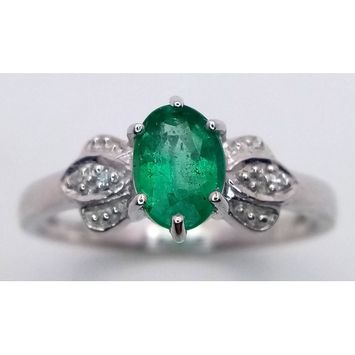 276 - A 9k White Gold, Emerald and Diamond Ring. An oval cut, 0.515ct Siberian emerald with 0.016ctw of di... 