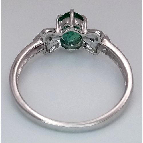 276 - A 9k White Gold, Emerald and Diamond Ring. An oval cut, 0.515ct Siberian emerald with 0.016ctw of di... 