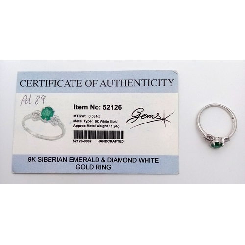 276 - A 9k White Gold, Emerald and Diamond Ring. An oval cut, 0.515ct Siberian emerald with 0.016ctw of di... 