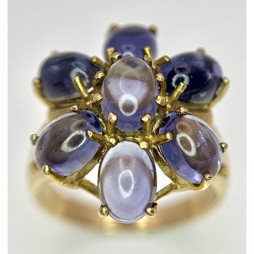 283 - A 9K Yellow Gold Iolite Gemstone Ring. Seven stones of 4.45ctw, oval cut Indian Iolites. Size N. 5.4... 