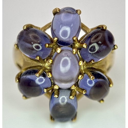 283 - A 9K Yellow Gold Iolite Gemstone Ring. Seven stones of 4.45ctw, oval cut Indian Iolites. Size N. 5.4... 