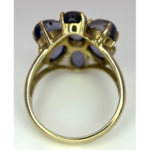283 - A 9K Yellow Gold Iolite Gemstone Ring. Seven stones of 4.45ctw, oval cut Indian Iolites. Size N. 5.4... 