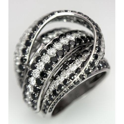 11 - AN 18K WHITE GOLD WHITE & BLACK DIAMOND FANCY CROSSOVER RING. 3.60CT , 14.4G TOTAL WEIGHT , SIZE I. ... 