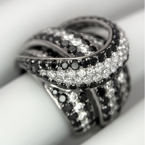 11 - AN 18K WHITE GOLD WHITE & BLACK DIAMOND FANCY CROSSOVER RING. 3.60CT , 14.4G TOTAL WEIGHT , SIZE I. ... 