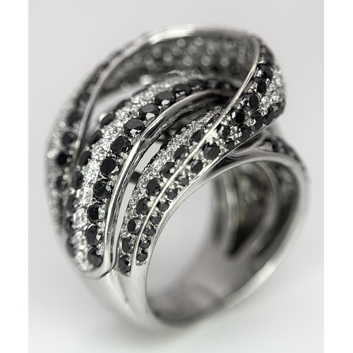 11 - AN 18K WHITE GOLD WHITE & BLACK DIAMOND FANCY CROSSOVER RING. 3.60CT , 14.4G TOTAL WEIGHT , SIZE I. ... 
