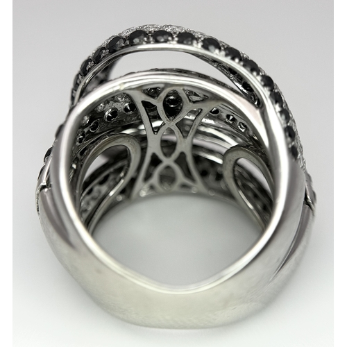 11 - AN 18K WHITE GOLD WHITE & BLACK DIAMOND FANCY CROSSOVER RING. 3.60CT , 14.4G TOTAL WEIGHT , SIZE I. ... 