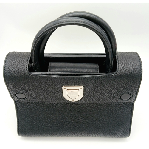 227 - A Christian Dior Black Diorever Handbag. Leather exterior with silver-toned hardware, two rolled lea... 