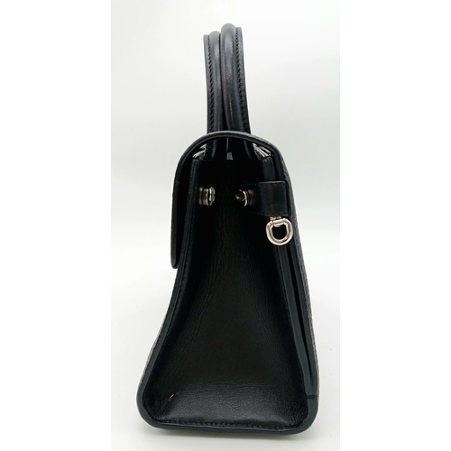 227 - A Christian Dior Black Diorever Handbag. Leather exterior with silver-toned hardware, two rolled lea... 