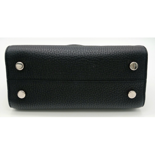 227 - A Christian Dior Black Diorever Handbag. Leather exterior with silver-toned hardware, two rolled lea... 