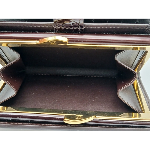 313 - A Louis Vuitton Vernis Amarante Monogram Purse. Dark burgundy patent leather exterior with gold-tone... 