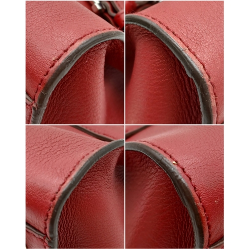 355 - A Salvatore Ferragamo Red Leather Handbag. Red leather exterior with silver-toned hardware, dual top... 