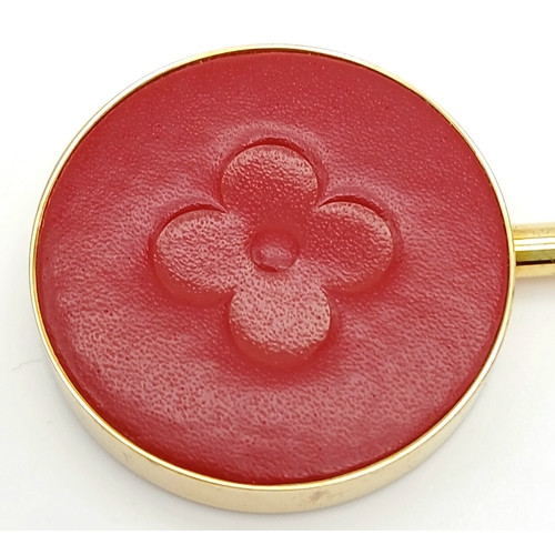 299 - A Louis Vuitton Red and Gold-Toned Monogram Flower Bag Holder. Gold-toned hardware with a red circul... 