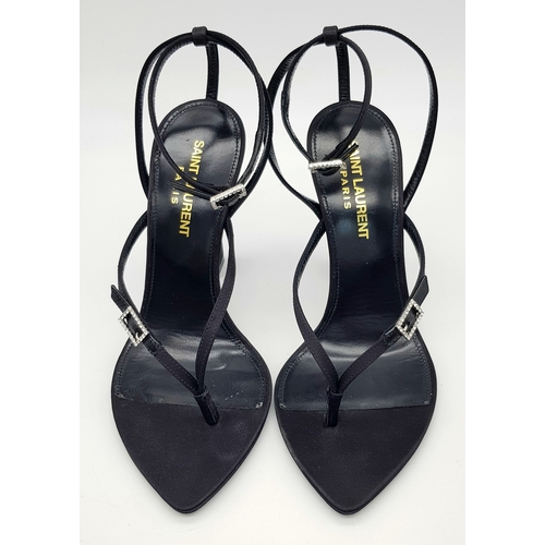 219 - A pair of Saint Laurent strappy heeled sandals. Black satin exterior with leather insoles, featuring... 