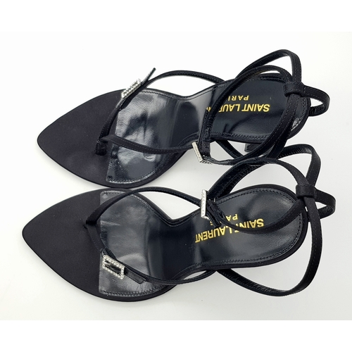 219 - A pair of Saint Laurent strappy heeled sandals. Black satin exterior with leather insoles, featuring... 