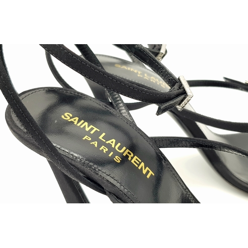 219 - A pair of Saint Laurent strappy heeled sandals. Black satin exterior with leather insoles, featuring... 