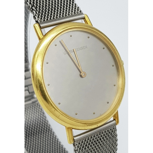 31 - A Georg Jensen 18K Gold Watch. Mesh bracelet. 18k gold case - 35mm. Silver tone dial. Quartz movemen... 
