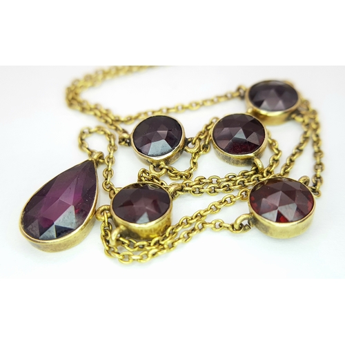 113 - An Edwardian 21K Gold and Garnet Lavaliere necklace. 42cm length. 6.2g total weight.