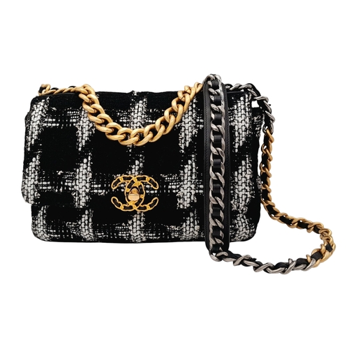 A Chanel Black and White Tweed Flap Bag. Quilted tweed exterior with gold toned hardware, leather-interwoven chain handle and magnetic closure. Black textile interior with a main compartment and one inner zipped pocket. Some signs of wear and tear exterior. Comes with card of authenticity and COA. Approx 27cm width x 16cm height x 8cm depth. Please see photos or request a condition report. STK022136
