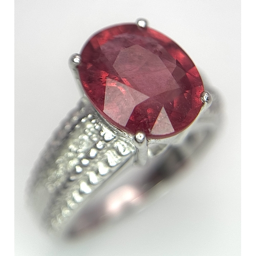 988 - An 18K White Gold, Royal Ruby and Diamond Ring. A 5.038 Madagascan oval cut Royal ruby with 0.084ctw... 