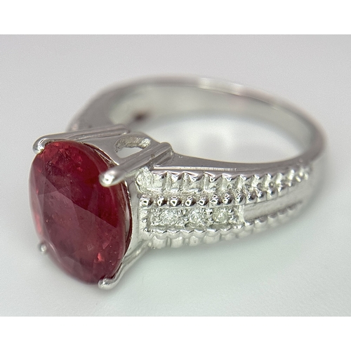 988 - An 18K White Gold, Royal Ruby and Diamond Ring. A 5.038 Madagascan oval cut Royal ruby with 0.084ctw... 