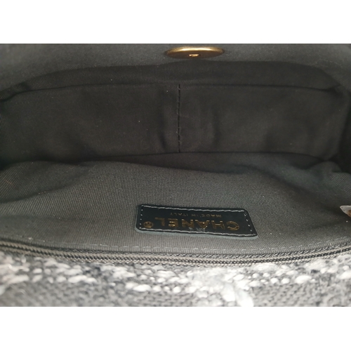 60 - A Chanel Black and Grey Tweed Flap Bag. Wool tweed exterior with gold-toned hardware, chain top hand... 