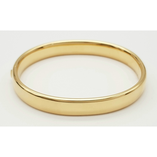 141 - A Bucherer 18K yellow gold solid bangle. Total weight 24.3G. Diameter 6.8cm. Comes with original pre... 
