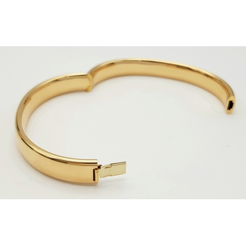 141 - A Bucherer 18K yellow gold solid bangle. Total weight 24.3G. Diameter 6.8cm. Comes with original pre... 