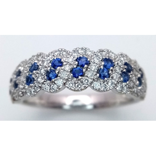 129 - An 18K White Gold, Sapphire and Diamond Cluster Ring. 18 round cut sapphires in diagonal pair form -... 