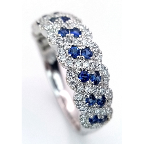 129 - An 18K White Gold, Sapphire and Diamond Cluster Ring. 18 round cut sapphires in diagonal pair form -... 