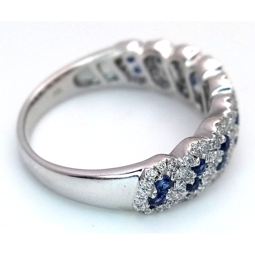 129 - An 18K White Gold, Sapphire and Diamond Cluster Ring. 18 round cut sapphires in diagonal pair form -... 