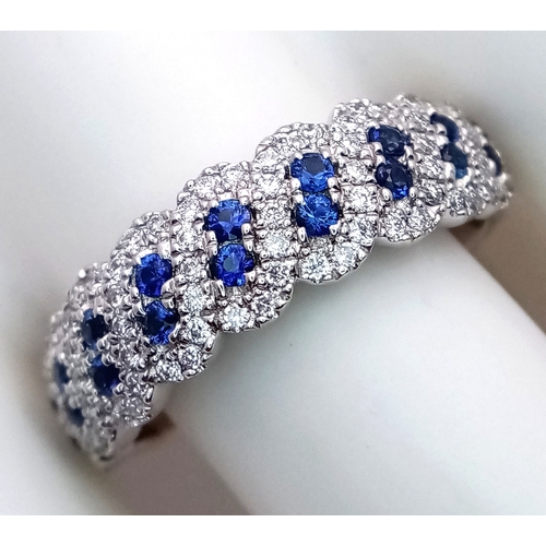 129 - An 18K White Gold, Sapphire and Diamond Cluster Ring. 18 round cut sapphires in diagonal pair form -... 