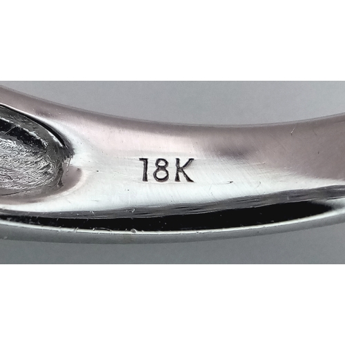 129 - An 18K White Gold, Sapphire and Diamond Cluster Ring. 18 round cut sapphires in diagonal pair form -... 